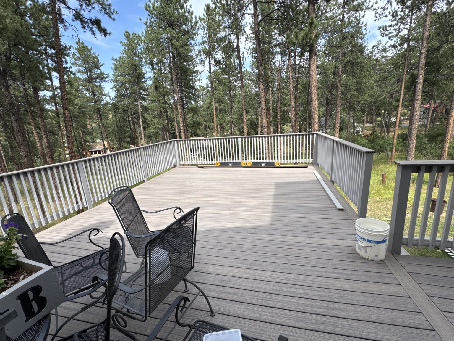 Gray composite deck surrounded by trees